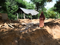 People stand in their broken house by flood water in Feni District, Bangladesh, on August 29, 2024. At least 52 people are killed, a total o...