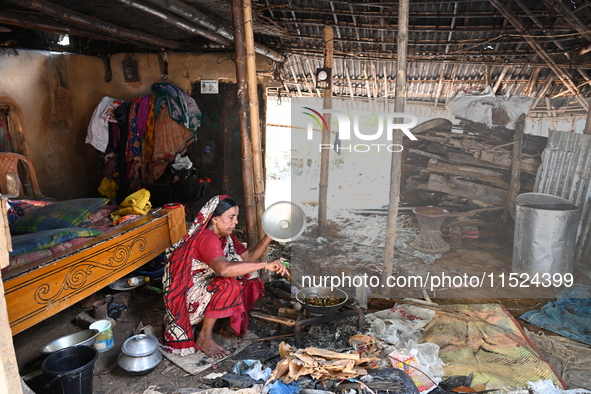 A woman cooks in her broken house due to flood water in Feni District, Bangladesh, on August 29, 2024. At least 52 people are killed, a tota...