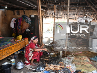 A woman cooks in her broken house due to flood water in Feni District, Bangladesh, on August 29, 2024. At least 52 people are killed, a tota...