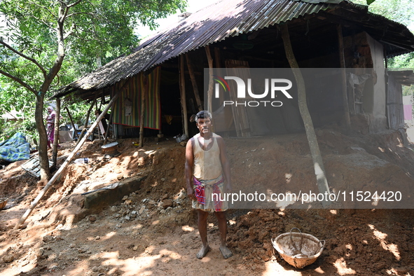 People stand in their broken house by flood water in Feni District, Bangladesh, on August 29, 2024. At least 52 people are killed, a total o...