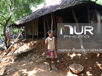 People stand in their broken house by flood water in Feni District, Bangladesh, on August 29, 2024. At least 52 people are killed, a total o...