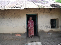 People stand in their broken house by flood water in Feni District, Bangladesh, on August 29, 2024. At least 52 people are killed, a total o...