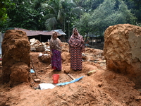 People stand in their broken house by flood water in Feni District, Bangladesh, on August 29, 2024. At least 52 people are killed, a total o...