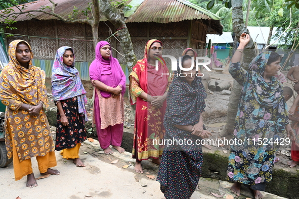 Flood-affected people wait on a street in Feni District, Bangladesh, on August 29, 2024. At least 52 people are killed, a total of 43 upazil...