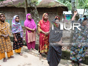 Flood-affected people wait on a street in Feni District, Bangladesh, on August 29, 2024. At least 52 people are killed, a total of 43 upazil...