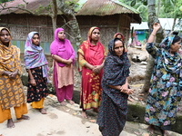 Flood-affected people wait on a street in Feni District, Bangladesh, on August 29, 2024. At least 52 people are killed, a total of 43 upazil...