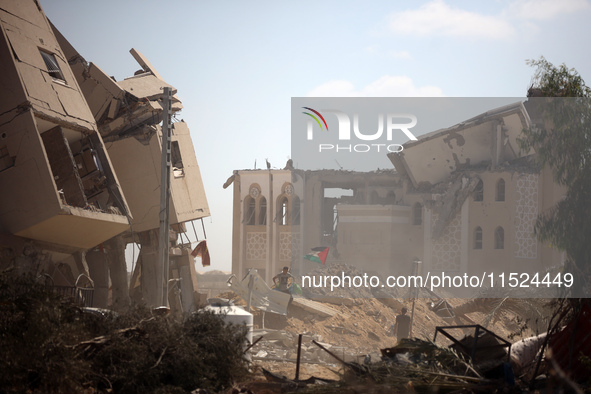 Palestinians collect their belongings and inspect the destruction caused by Israeli airstrikes in eastern Deir al-Balah in central Gaza Stri...