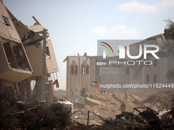 Palestinians collect their belongings and inspect the destruction caused by Israeli airstrikes in eastern Deir al-Balah in central Gaza Stri...