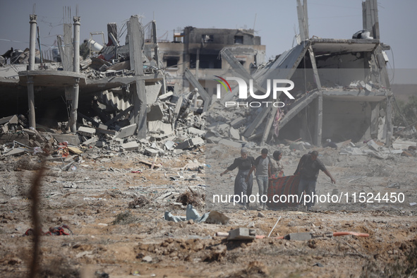 Palestinians collect their belongings and inspect the destruction caused by Israeli airstrikes in eastern Deir al-Balah in central Gaza Stri...