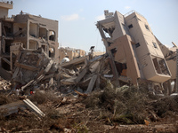 Palestinians collect their belongings and inspect the destruction caused by Israeli airstrikes in eastern Deir al-Balah in central Gaza Stri...