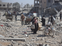 Palestinians collect their belongings and inspect the destruction caused by Israeli airstrikes in eastern Deir al-Balah in central Gaza Stri...