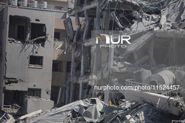 Palestinians collect their belongings and inspect the destruction caused by Israeli airstrikes in eastern Deir al-Balah in central Gaza Stri...