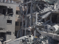 Palestinians collect their belongings and inspect the destruction caused by Israeli airstrikes in eastern Deir al-Balah in central Gaza Stri...