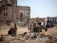 Palestinians collect their belongings and inspect the destruction caused by Israeli airstrikes in eastern Deir al-Balah in central Gaza Stri...