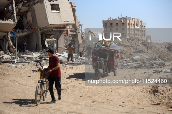 Palestinians collect their belongings and inspect the destruction caused by Israeli airstrikes in eastern Deir al-Balah in central Gaza Stri...