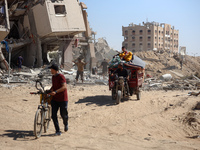 Palestinians collect their belongings and inspect the destruction caused by Israeli airstrikes in eastern Deir al-Balah in central Gaza Stri...