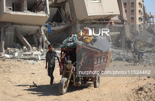 Palestinians collect their belongings and inspect the destruction caused by Israeli airstrikes in eastern Deir al-Balah in central Gaza Stri...