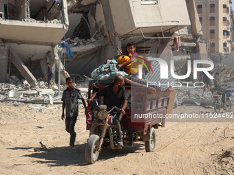 Palestinians collect their belongings and inspect the destruction caused by Israeli airstrikes in eastern Deir al-Balah in central Gaza Stri...