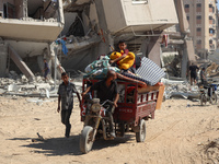 Palestinians collect their belongings and inspect the destruction caused by Israeli airstrikes in eastern Deir al-Balah in central Gaza Stri...