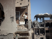 Palestinians collect their belongings and inspect the destruction caused by Israeli airstrikes in eastern Deir al-Balah in central Gaza Stri...