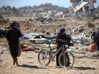 Palestinians collect their belongings and inspect the destruction caused by Israeli airstrikes in eastern Deir al-Balah in central Gaza Stri...