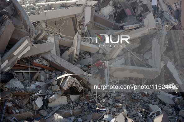 Palestinians collect their belongings and inspect the destruction caused by Israeli airstrikes in eastern Deir al-Balah in central Gaza Stri...