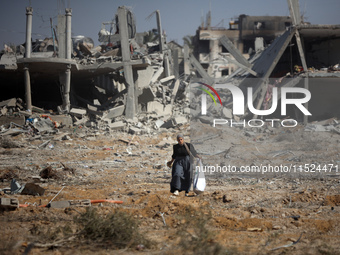 Palestinians collect their belongings and inspect the destruction caused by Israeli airstrikes in eastern Deir al-Balah in central Gaza Stri...