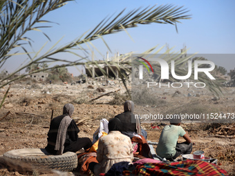 Palestinians collect their belongings and inspect the destruction caused by Israeli airstrikes in eastern Deir al-Balah in central Gaza Stri...