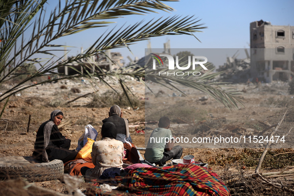 Palestinians collect their belongings and inspect the destruction caused by Israeli airstrikes in eastern Deir al-Balah in central Gaza Stri...