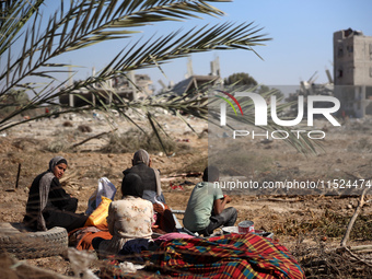 Palestinians collect their belongings and inspect the destruction caused by Israeli airstrikes in eastern Deir al-Balah in central Gaza Stri...