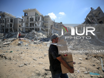 Palestinians collect their belongings and inspect the destruction caused by Israeli airstrikes in eastern Deir al-Balah in central Gaza Stri...