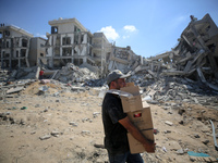 Palestinians collect their belongings and inspect the destruction caused by Israeli airstrikes in eastern Deir al-Balah in central Gaza Stri...