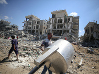 Palestinians collect their belongings and inspect the destruction caused by Israeli airstrikes in eastern Deir al-Balah in central Gaza Stri...