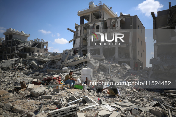 Palestinians collect their belongings and inspect the destruction caused by Israeli airstrikes in eastern Deir al-Balah in central Gaza Stri...