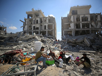 Palestinians collect their belongings and inspect the destruction caused by Israeli airstrikes in eastern Deir al-Balah in central Gaza Stri...