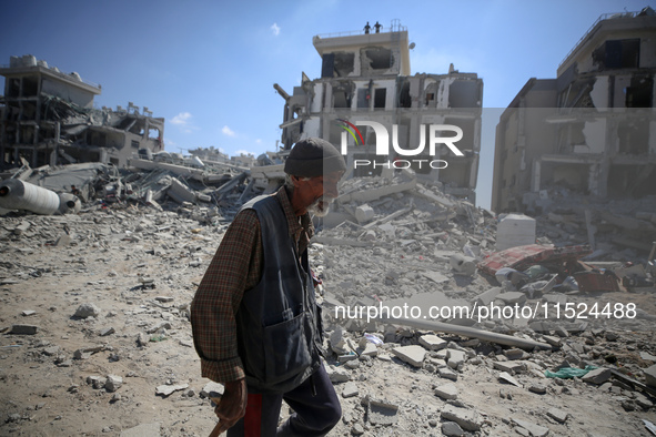 Palestinians collect their belongings and inspect the destruction caused by Israeli airstrikes in eastern Deir al-Balah in central Gaza Stri...