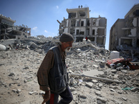 Palestinians collect their belongings and inspect the destruction caused by Israeli airstrikes in eastern Deir al-Balah in central Gaza Stri...