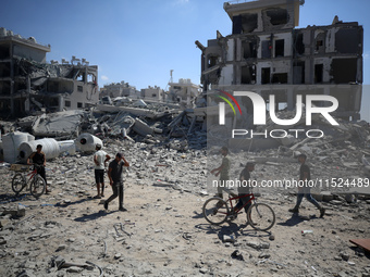 Palestinians collect their belongings and inspect the destruction caused by Israeli airstrikes in eastern Deir al-Balah in central Gaza Stri...