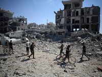 Palestinians collect their belongings and inspect the destruction caused by Israeli airstrikes in eastern Deir al-Balah in central Gaza Stri...