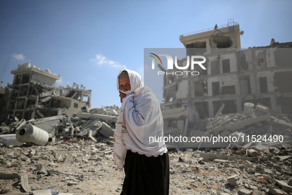 Palestinians collect their belongings and inspect the destruction caused by Israeli airstrikes in eastern Deir al-Balah in central Gaza Stri...