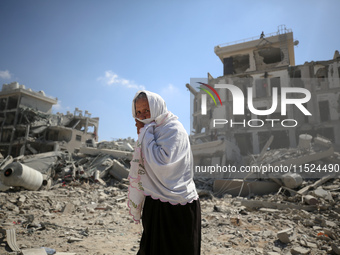 Palestinians collect their belongings and inspect the destruction caused by Israeli airstrikes in eastern Deir al-Balah in central Gaza Stri...