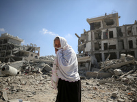 Palestinians collect their belongings and inspect the destruction caused by Israeli airstrikes in eastern Deir al-Balah in central Gaza Stri...