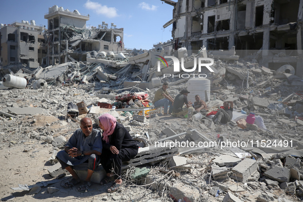 Palestinians collect their belongings and inspect the destruction caused by Israeli airstrikes in eastern Deir al-Balah in central Gaza Stri...