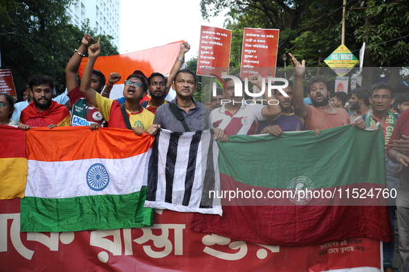 Supporters of the arch-rival football clubs East Bengal and Mohammedan Sporting Club shout slogans during a protest march against the rape a...