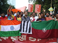 Supporters of the arch-rival football clubs East Bengal and Mohammedan Sporting Club shout slogans during a protest march against the rape a...