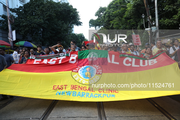 Supporters of the arch-rival football clubs East Bengal and Mohammedan Sporting Club shout slogans during a protest march against the rape a...