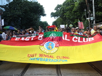 Supporters of the arch-rival football clubs East Bengal and Mohammedan Sporting Club shout slogans during a protest march against the rape a...