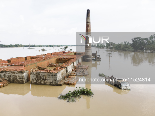 A brickyard and a car are half submerged in flood water in the Chanpur area of Chagalnaia upazila of Feni district of Chittagong division of...