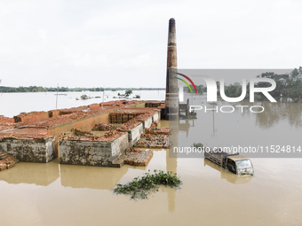 A brickyard and a car are half submerged in flood water in the Chanpur area of Chagalnaia upazila of Feni district of Chittagong division of...