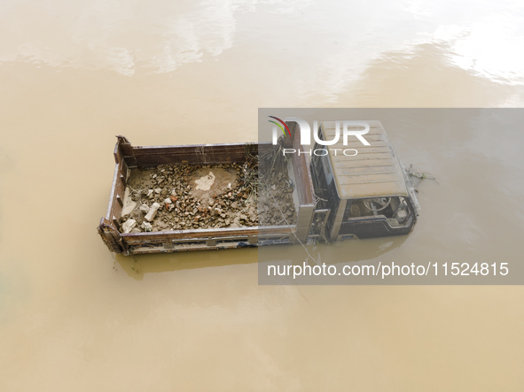 A car is half submerged in the flood water in Chanpur area of Chagalnaia upazila of Feni district in Chittagong division, Bangladesh, on Aug...